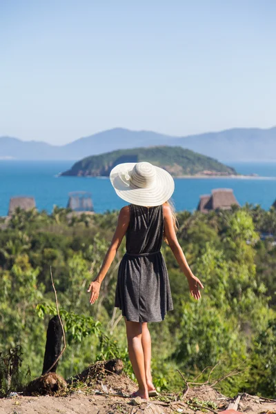 woman in a dress is traveling on the precipice of the mountain in a white hat Vietnam