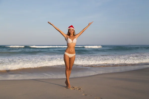 サンタ帽子新年旅行休暇赤でビーチで女の子 — ストック写真