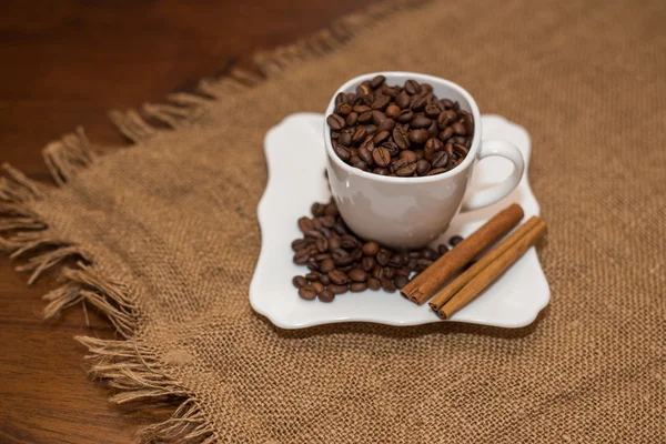 Coffee beans and cinnamon white cup — Stock Photo, Image