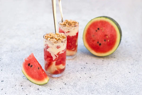 Vandmelonsaft og yoghurt dessert i et glas med nødder - Stock-foto