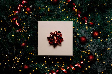 Noel hediyesi olarak bokeh ışıkları ve köknar ağacının arka planında kurdele. Üst yatay görünüm telif uzayı.