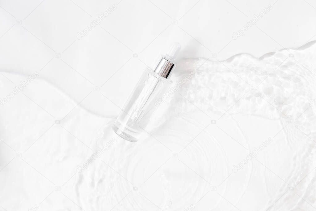 Glass Bottle with fluid collagen and hyaluronic acid, hydration skin. Top flatlay view copyspace. Abstract water background.