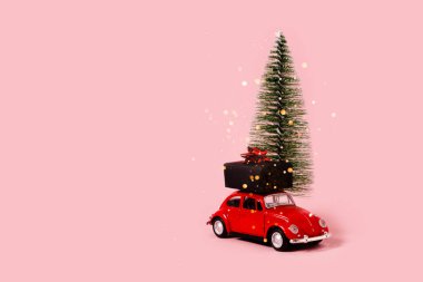 Hediyeli ve noel süslemeli oyuncak araba. Konfeti ve bokeh ışıkları. Üst yatay görünüm telif uzayı.