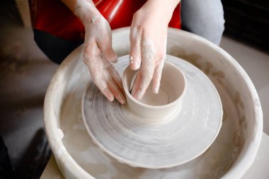 Çömlekçi çarkının üzerinde çömlek kupası yapan kadın eller. El yapımı ve el yapımı konsept. 