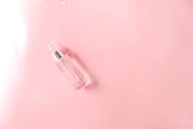 Sıvı kolajen ve hiyalüronik asit içeren cam şişe, hidrasyon derisi. Üst düz görünüm telif uzayı. Soyut su arkaplanı.