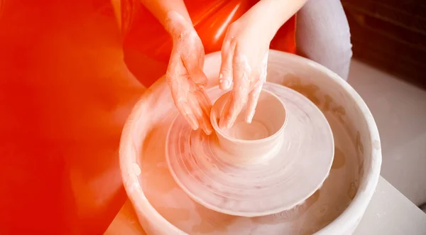 Manos femeninas confeccionando una taza de cerámica en un volante de alfarero. Concepto artesanal y artesanal. Copyspace vista horizontal superior. — Foto de Stock