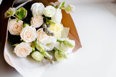 Çiçekçi kadın çiçek buketi yapıyor. Adım adım icraat. Üst yatay görünüm telif uzayı pembe arkaplan