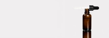 Yüz ve vücut bakımı konsepti, siyah cam şişelerde sağlıklı doğal kozmetik ürünler. Pipetli Hyaluronik asit.