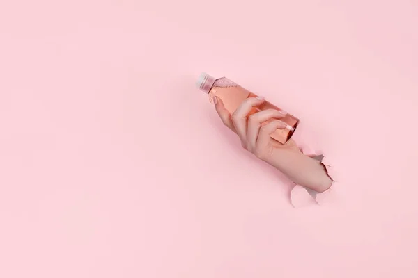 Cam şişeyi tutan kadın yırtık kağıt..