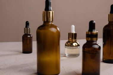 Kehribar cam şişelerde pipetli eko mineral yağı. Şeffaf hyaluronik serum jeli ve cilt bakımı konsepti. Düşürme camının üst yatay görünümü telif uzayı.