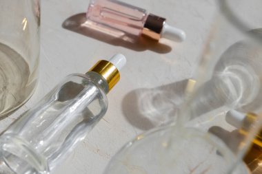 Cam şişelerde pipet damlacıklı eko mineral yağı. Şeffaf hyaluronik serum jeli ve cilt bakımı konsepti. Üst yatay görünüm telif uzayı