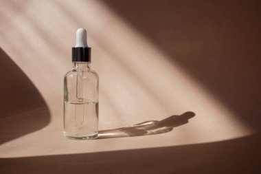 Kehribar cam şişelerde pipetli eko mineral yağı. Şeffaf hyaluronik serum jeli ve cilt bakımı konsepti. Üst yatay görünüm telif uzayı