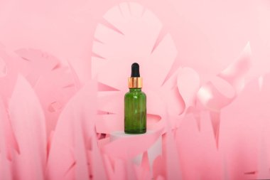 Beyaz bir podyumda üzerinde pipeti olan damlatan cam şişeler. Şeffaf hyaluronik doğal güzellik mineral ürünü ve eko serumu cilt bakımı kavramı.