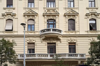 Büyük ve küçük balkonlu eski apartman önü.