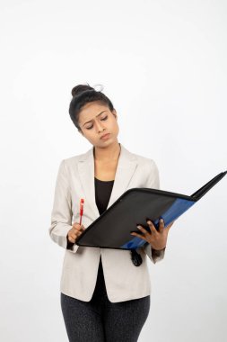 Ofisteki kadın elinde bir dosya, kalem ve sunum tutuyor. Resmi giyinmiş genç bir kadın beyaz arka planda beyaz ceket giyiyor..