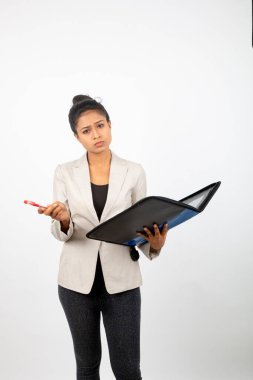 Ofisteki kadın elinde bir dosya, kalem ve sunum tutuyor. Resmi giyinmiş genç bir kadın beyaz arka planda beyaz ceket giyiyor..