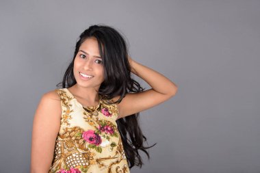 Çiçekli bir bluz, siyah tayt ve siyah topuklu giyen çekici genç bir kadın, neşeli yüz ifadeleri ve farklı duygularla poz veriyor, modern tarzı, zarafeti sergiliyor..