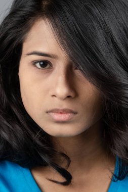 Genç bir kadın özgüvenle mavi tişört, sıkıntılı kot pantolon, topuklu ayakkabı giyerek poz veriyor, cazibe ve zarafetle gelişigüzel bir şehir tarzı sergiliyor, saç bakımı, özgürlük, kendini ifade etme projesi için uygun.