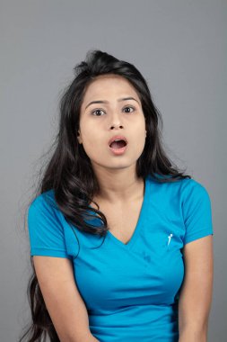 Genç bir kadın özgüvenle mavi tişört, sıkıntılı kot pantolon, topuklu ayakkabı giyerek poz veriyor, cazibe ve zarafetle gelişigüzel bir şehir tarzı sergiliyor, saç bakımı, özgürlük, kendini ifade etme projesi için uygun.