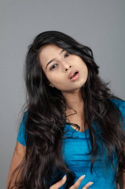 Genç bir kadın özgüvenle mavi tişört, sıkıntılı kot pantolon, topuklu ayakkabı giyerek poz veriyor, cazibe ve zarafetle gelişigüzel bir şehir tarzı sergiliyor, saç bakımı, özgürlük, kendini ifade etme projesi için uygun.