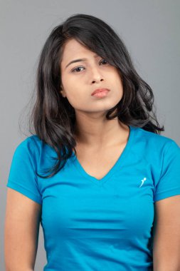 Genç bir kadın özgüvenle mavi tişört, sıkıntılı kot pantolon, topuklu ayakkabı giyerek poz veriyor, cazibe ve zarafetle gelişigüzel bir şehir tarzı sergiliyor, saç bakımı, özgürlük, kendini ifade etme projesi için uygun.