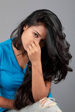 Genç bir kadın özgüvenle mavi tişört, sıkıntılı kot pantolon, topuklu ayakkabı giyerek poz veriyor, cazibe ve zarafetle gelişigüzel bir şehir tarzı sergiliyor, saç bakımı, özgürlük, kendini ifade etme projesi için uygun.