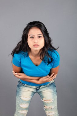 Genç bir kadın özgüvenle mavi tişört, sıkıntılı kot pantolon, topuklu ayakkabı giyerek poz veriyor, cazibe ve zarafetle gelişigüzel bir şehir tarzı sergiliyor, saç bakımı, özgürlük, kendini ifade etme projesi için uygun.