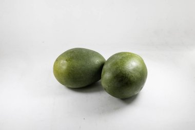 Taze yeşil mangolar beyaz arka planda izole edilmiş. Sağlıklı beslenme, egzotik meyveler, minimalist ve sağlıkla ilgili projeler için mükemmel bir kavram..