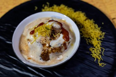 Lezzetli Hint safra Vada 'sı veya yoğurt, demirhindi turşusu ve zarif siyah tabakta servis edilen çıtır çıtır malzemeyle servis edilen safra bhalla. Geleneksel mutfak ve lezzetli atıştırmalıklar için ideal..