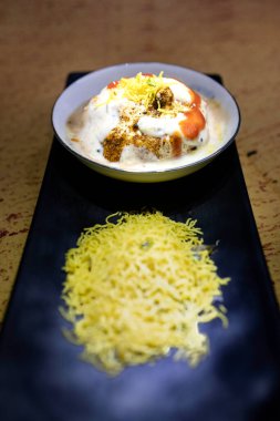 Lezzetli Hint safra Vada 'sı veya yoğurt, demirhindi turşusu ve zarif siyah tabakta servis edilen çıtır çıtır malzemeyle servis edilen safra bhalla. Geleneksel mutfak ve lezzetli atıştırmalıklar için ideal..