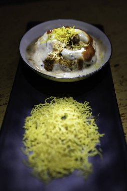 Lezzetli Hint safra Vada 'sı veya yoğurt, demirhindi turşusu ve zarif siyah tabakta servis edilen çıtır çıtır malzemeyle servis edilen safra bhalla. Geleneksel mutfak ve lezzetli atıştırmalıklar için ideal..