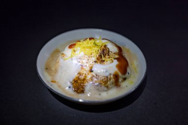 Lezzetli Hint safra Vada 'sı veya yoğurt, demirhindi turşusu ve zarif siyah tabakta servis edilen çıtır çıtır malzemeyle servis edilen safra bhalla. Geleneksel mutfak ve lezzetli atıştırmalıklar için ideal..