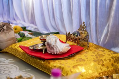 Shaligram shila, Nepal 'deki Kali Gandaki' nin nehir yatağından toplanan fosilleşmiş bir taş veya ammonit. Tanrı 'nın bir formu olarak kabul edilir. Bir Bengali evinde Satyanarayan (Vishnu) pooja için hazırlık.