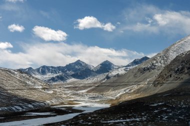 Dağ manzarası, kayaların güzel manzarası, beyaz bulutlarla dolu mavi gökyüzünün tepesindeki pitoresk dağ geçidi..