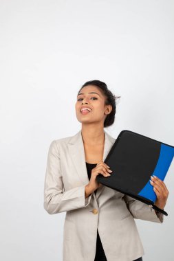 Ofisteki kadın bir dosya tutuyor ve sunum yapıyor. Resmi giyinmiş genç bir kadın beyaz ceket giyiyor ve elinde floder ile farklı ifadeler takınıyor.