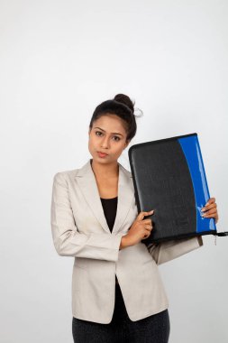 Ofisteki kadın bir dosya tutuyor ve sunum yapıyor. Resmi giyinmiş genç bir kadın beyaz ceket giyiyor ve elinde floder ile farklı ifadeler takınıyor.