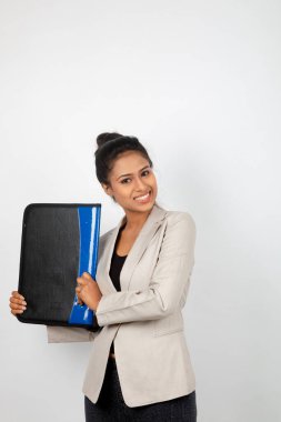 Ofisteki kadın bir dosya tutuyor ve sunum yapıyor. Resmi giyinmiş genç bir kadın beyaz ceket giyiyor ve elinde floder ile farklı ifadeler takınıyor.