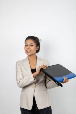 Ofisteki kadın bir dosya tutuyor ve sunum yapıyor. Resmi giyinmiş genç bir kadın beyaz ceket giyiyor ve elinde floder ile farklı ifadeler takınıyor.