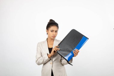 Ofisteki kadın bir dosya tutuyor ve sunum yapıyor. Resmi giyinmiş genç bir kadın beyaz ceket giyiyor elinde klasörle farklı ifadeler takınıyor.