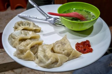 Tavuk momo ve tavuk çorbası, Nepal geleneksel yemek Momo tavuk ile doldurulmuş ve sonra pişirilmiş ve bir tabak üzerinde servis, seçici bir şekilde konuya odaklanmış.