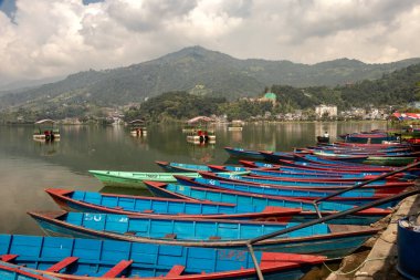 Pokhara, Nepal 'de sisli bir sabahta Phewa gölünde yüzen teknelerin güzel manzarası..