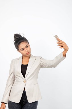 Kurumsal ofis hanımı, siyah saçlı, kalemle oynaşan, resmi olarak akıllı telefonlu beyaz ceketli beyaz arka planlı bir kadın..