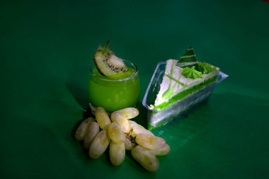 Tatlı. Hamur işi, mango içeceği, arka planda yeşil üzümler. Parlak. Makro. Kapat.