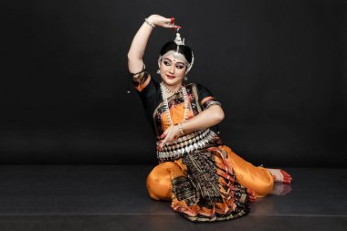 Renkli kostümler içinde Odissi dansı yapan bir kadın. Hint klasik dans formları.