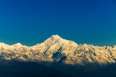 Kanchenjugha Dağı, Himalaya sıradağları, Sikkim, Hindistan 'da güneşin doğuşundan güzel bir gün ışığı. Şafak vakti dağlarda turuncu renkler