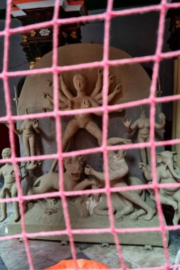 Kolkata, Batı Bengal, Hindistan - 19 Eylül 2021: Bir zanaatkar Hindistan 'ın Kumartuli bölgesindeki mobilyasız bir Durga idolü üzerinde yerel stüdyosunda çalışıyor.