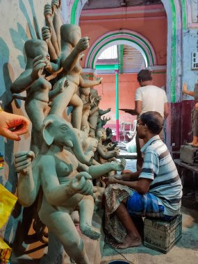 Kolkata, Batı Bengal, Hindistan - 19 Eylül 2021: Bir zanaatkar Hindistan 'ın Kumartuli bölgesindeki mobilyasız bir Durga idolü üzerinde yerel stüdyosunda çalışıyor.