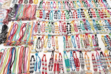 Geleneksel el yapımı çok renkli süslü saten süs Mala veya plastik boncuklu kolye Shantiniketan, Batı Bengal 'de Sonajhuri haat' ta satılıyor.