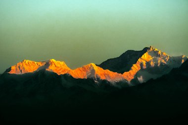 Kanchenjugha Dağı, Himalaya sıradağları, Sikkim, Hindistan 'da güneşin doğuşundan güzel bir gün ışığı. Şafak vakti dağlarda turuncu renkler