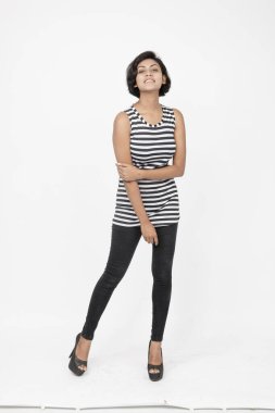 Siyah-beyaz çizgili kolsuz bluz, siyah kot, beyaz arka planda yüksek topuklu, moda, güzellik, kendine güven için ideal, minimal stil..